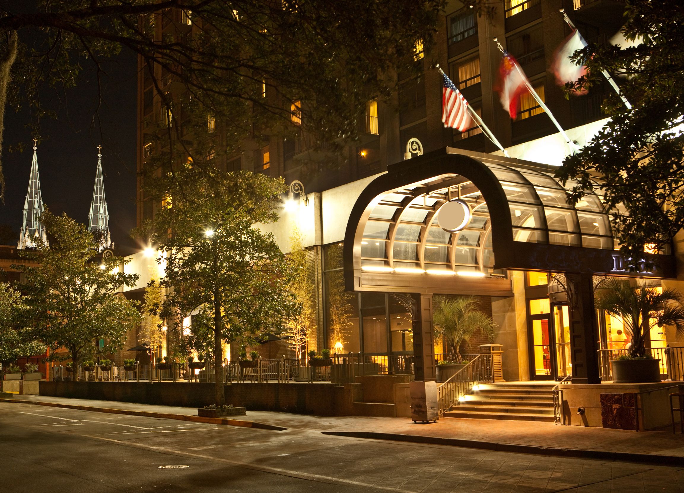 a building with a glass canopy and flags on the top