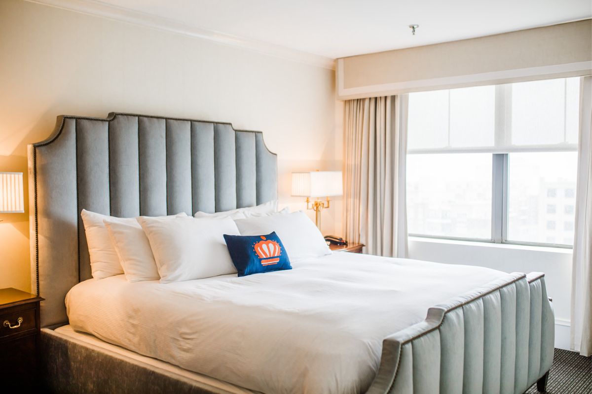 a bed with pillows and a lamp in a room