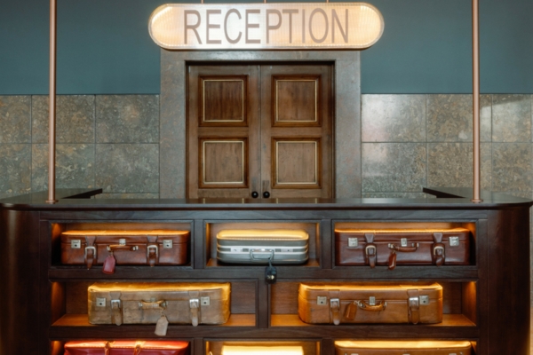 a reception desk with luggage on shelves