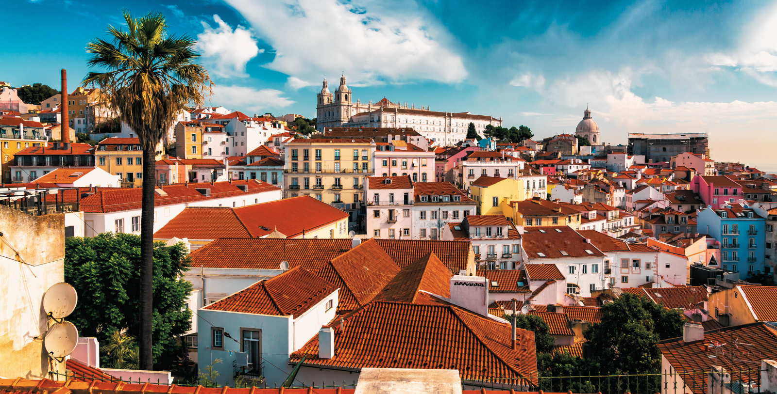 a city with red roofs and a building in the background