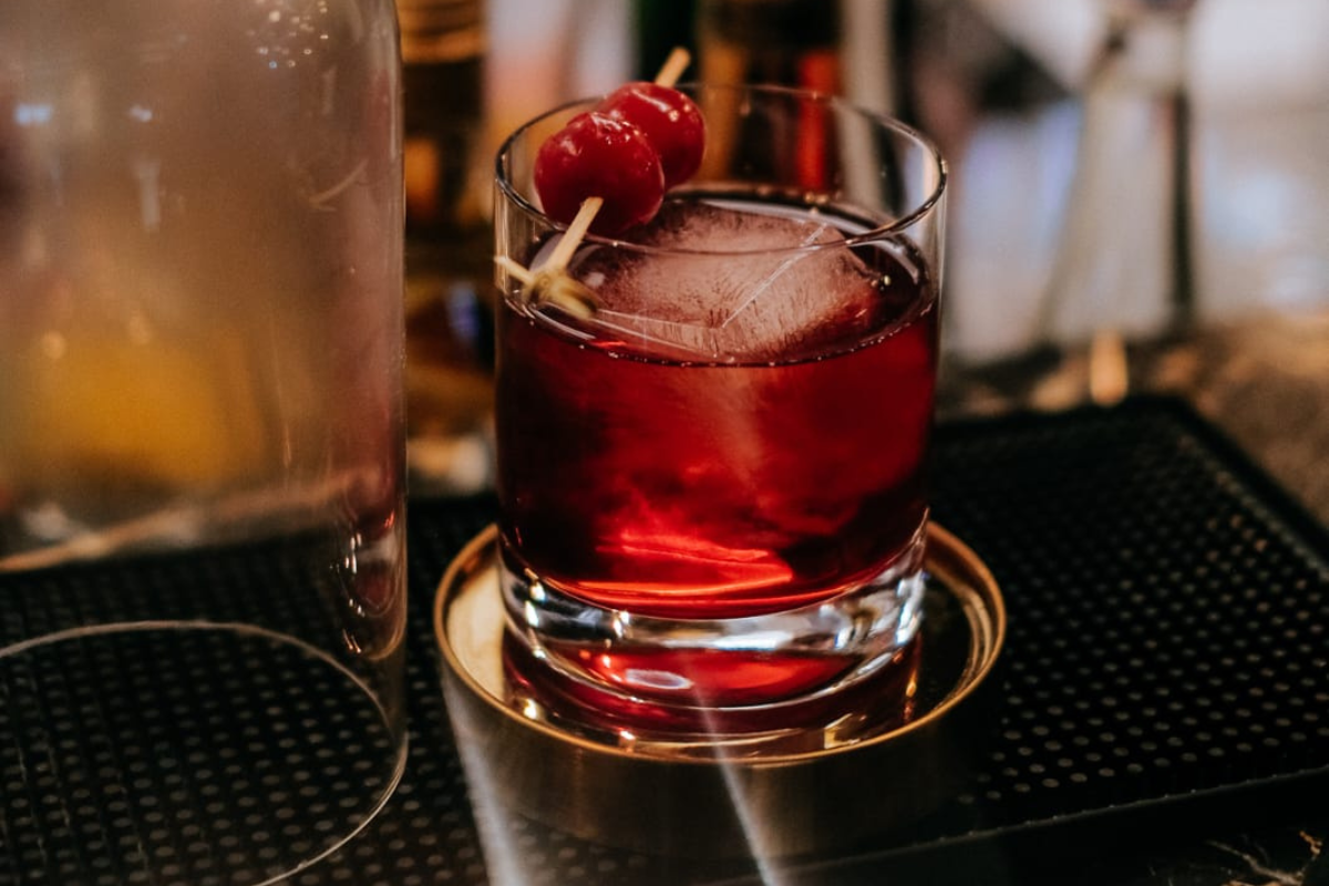 a glass with a cherry on top and a stick on top