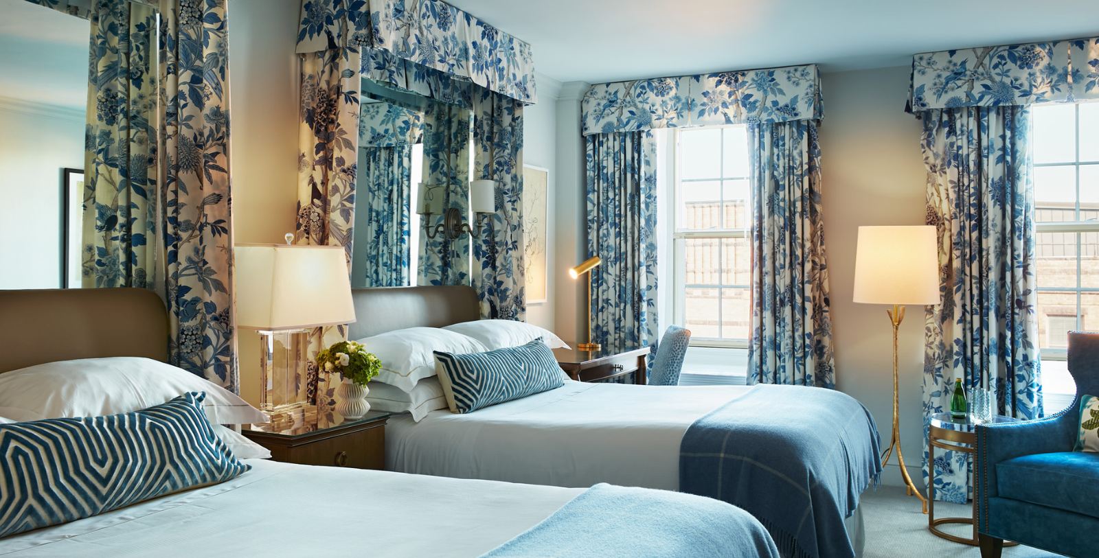 a room with two beds and a lamp