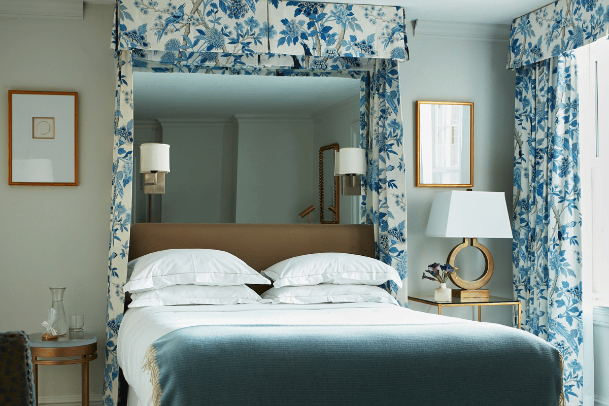 a bed with a blue blanket and a lamp