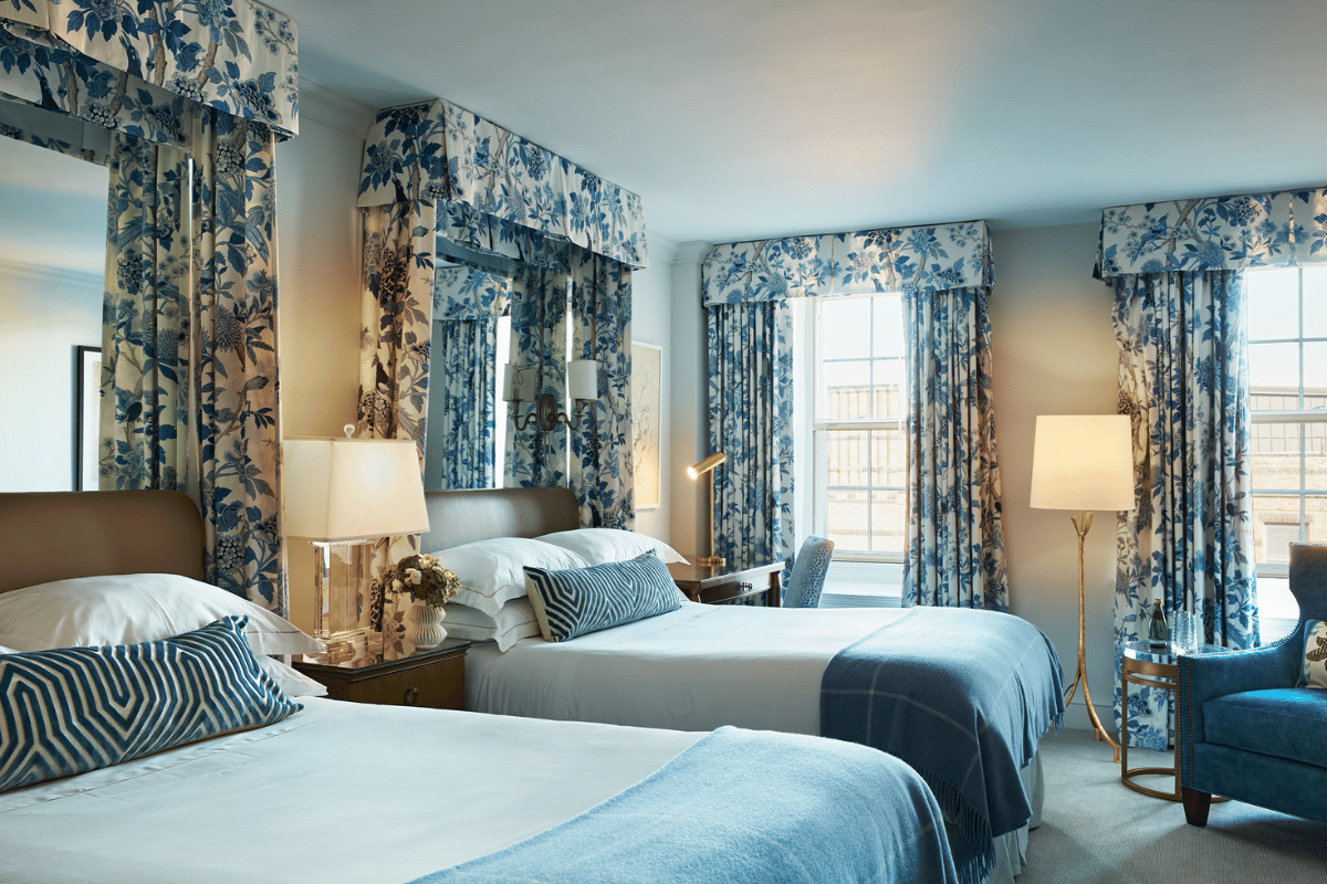 a room with two beds and a lamp