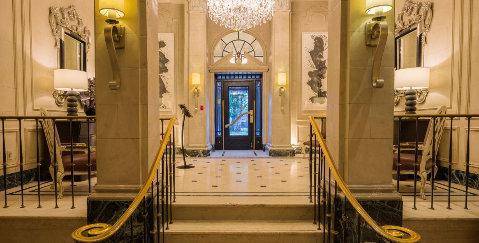 a hallway with a chandelier and a glass door