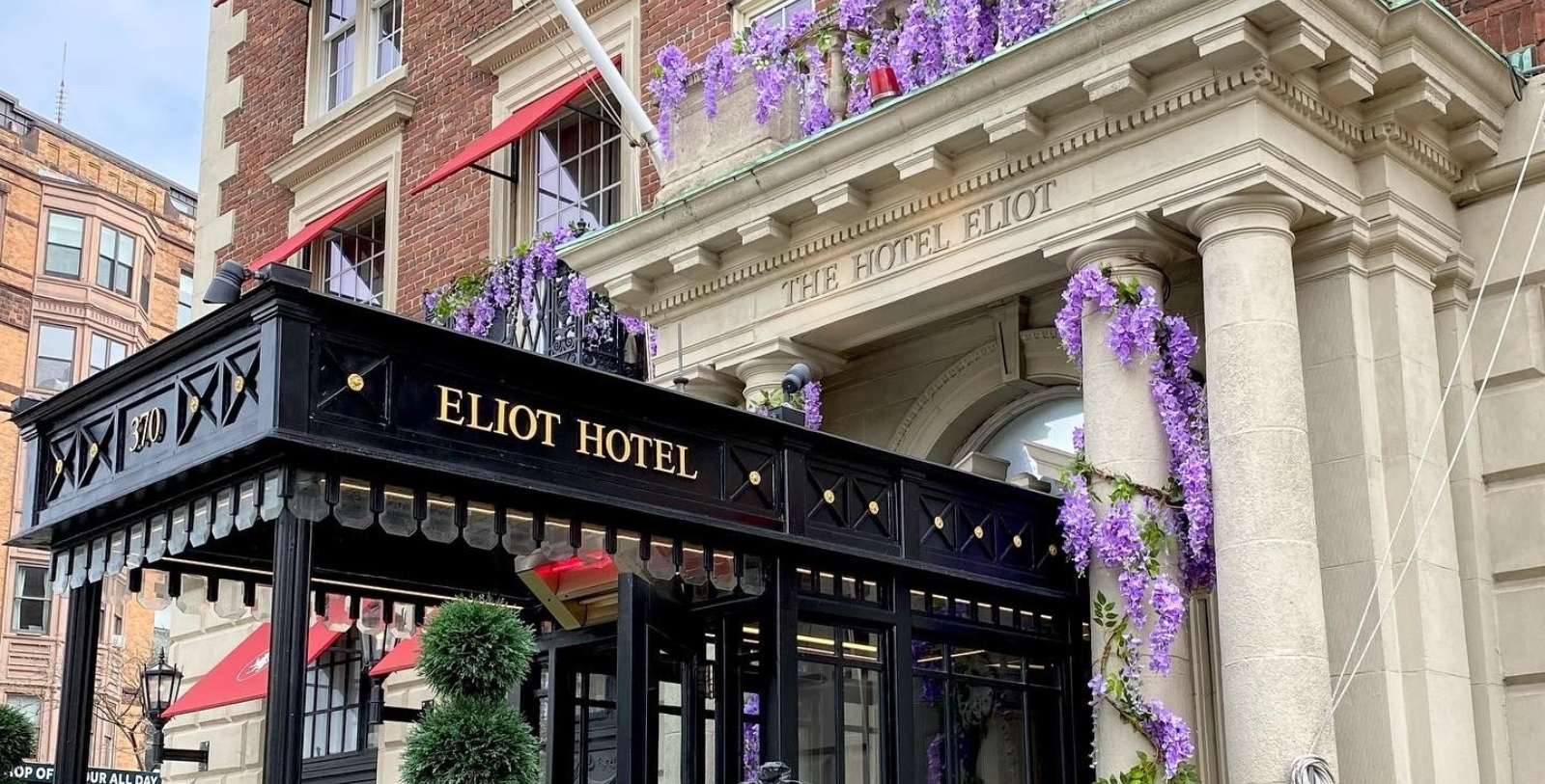 a building with purple flowers on the balcony
