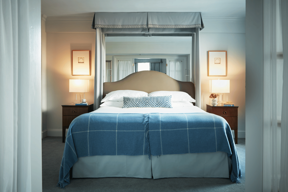 a bed with a blue blanket and pillows