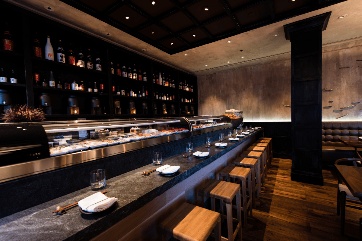 a restaurant with a bar and shelves of bottles