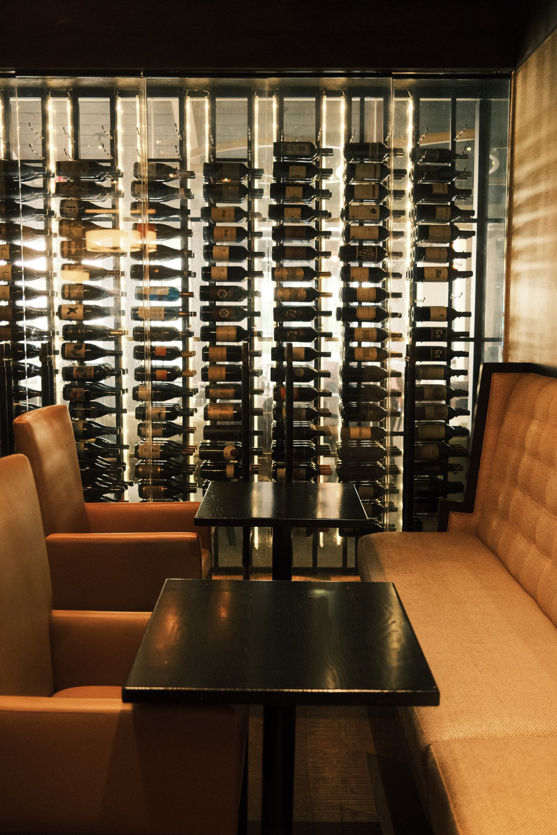 a table and chairs in a room with wine bottles