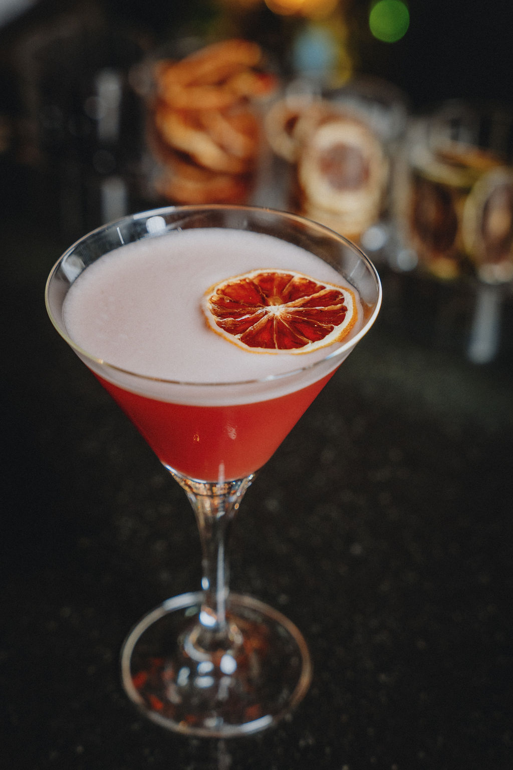 a glass with a drink and a slice of orange on top