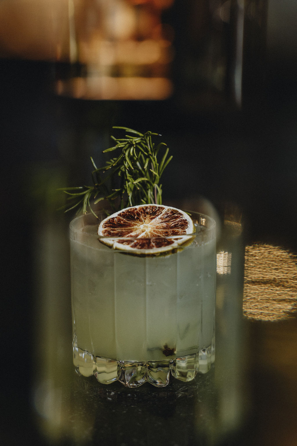 a glass with a drink and a slice of orange on top