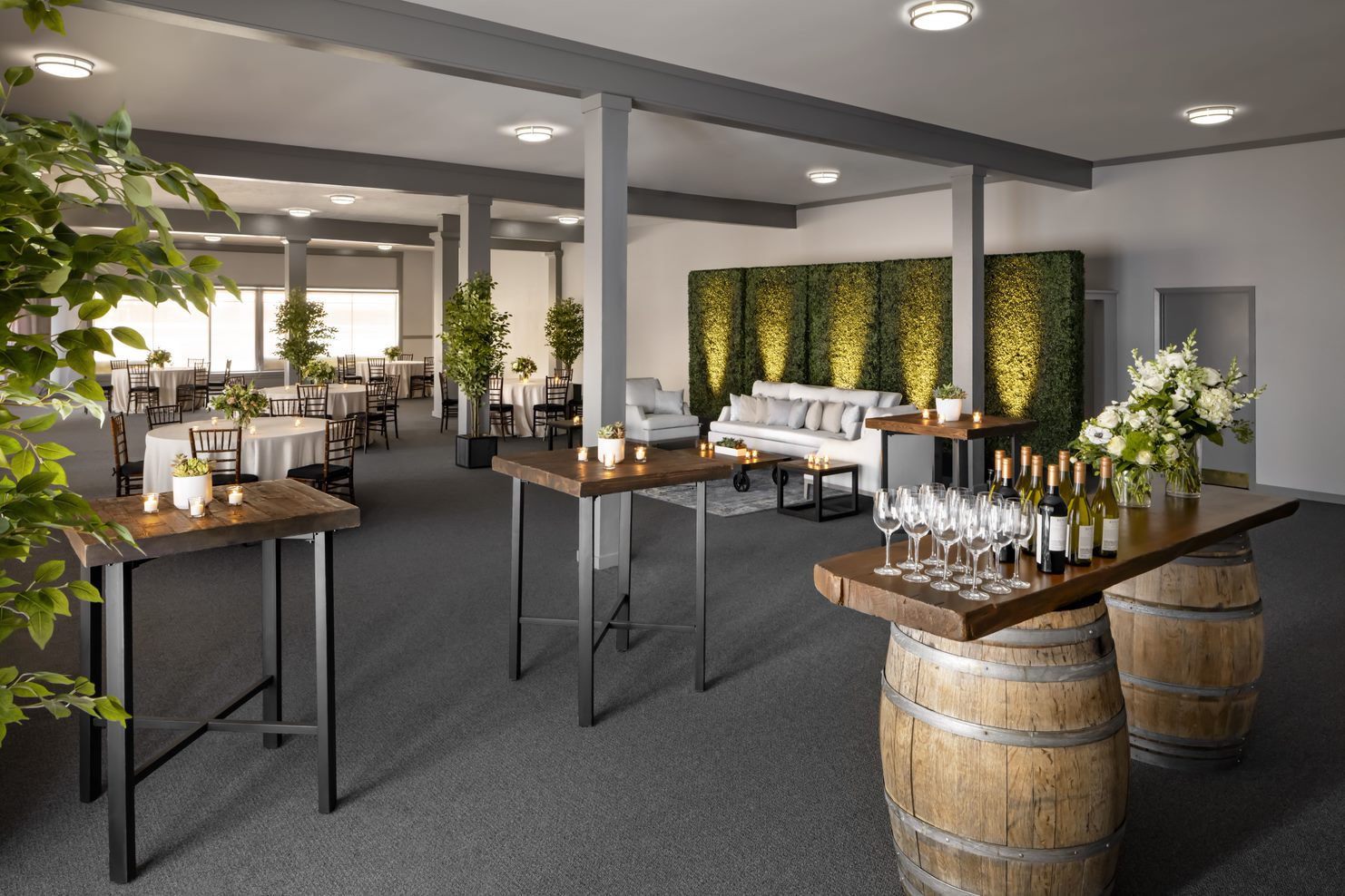 a room with tables and chairs and tables with wine glasses