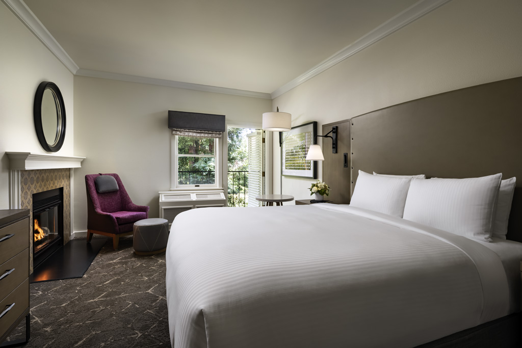 a hotel room with a bed and chairs