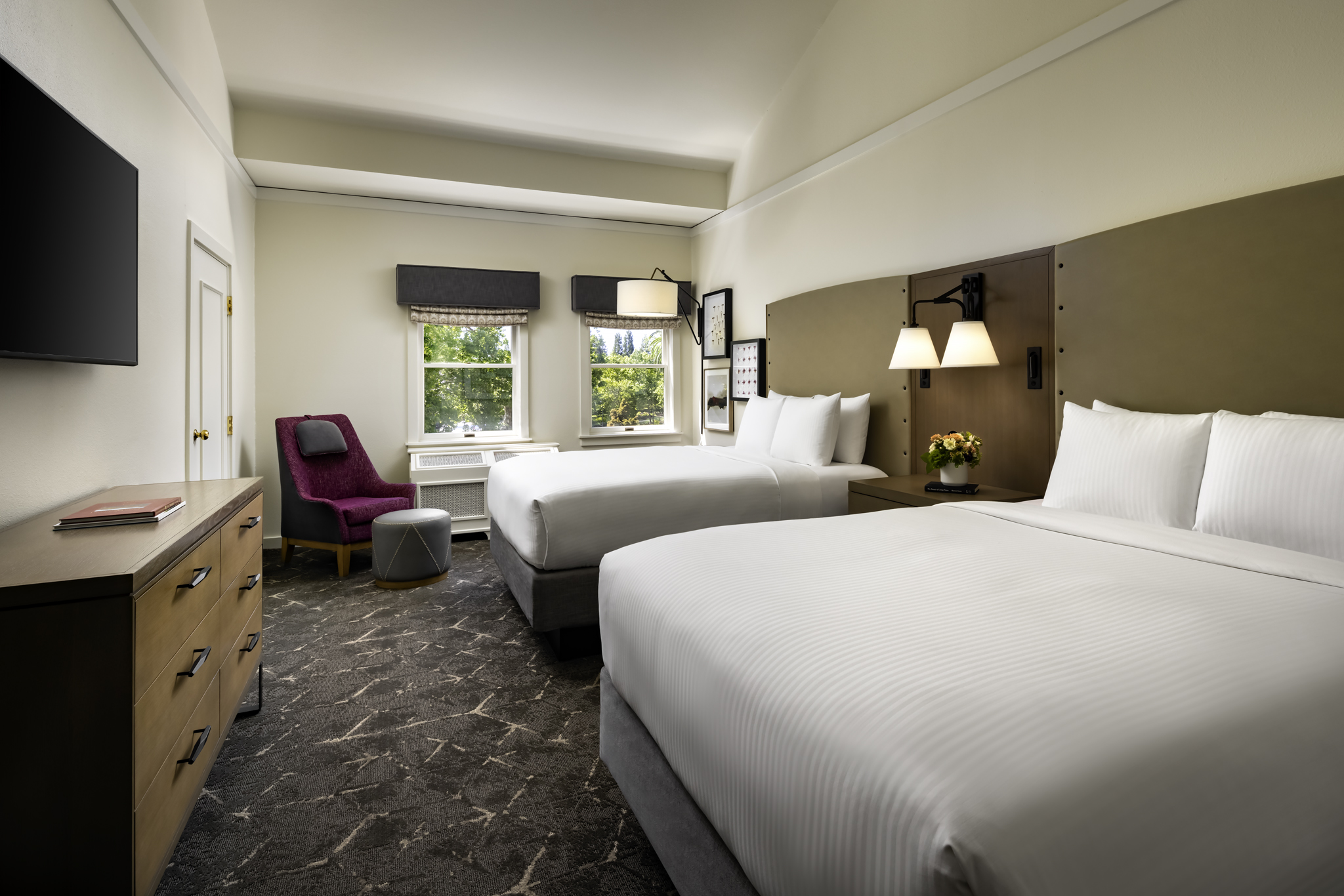 a room with two beds and a chair