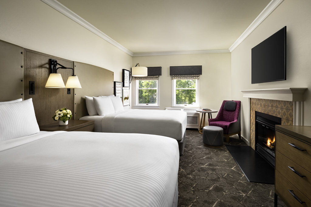 a room with two beds and a fireplace