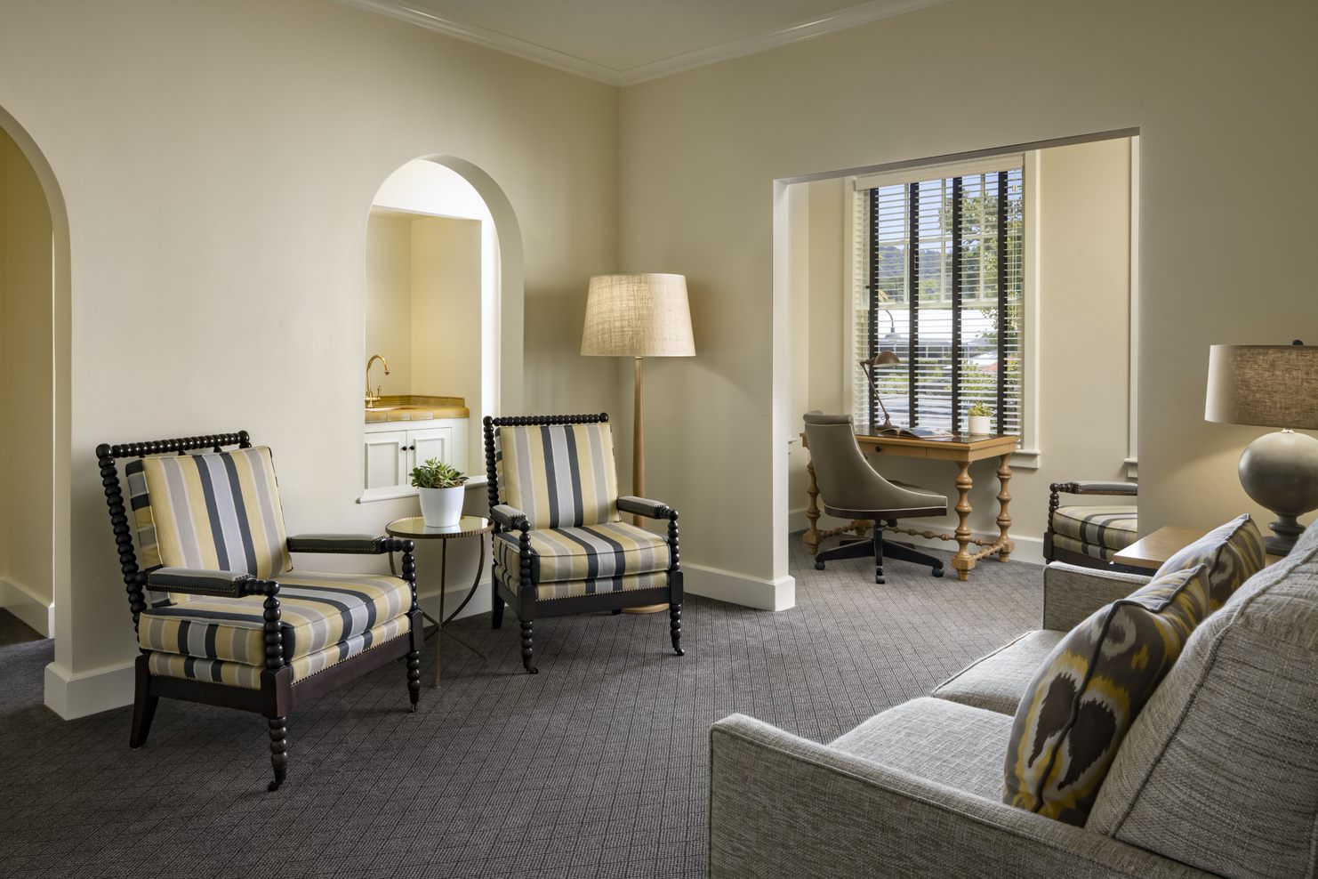 a room with a couch and chairs