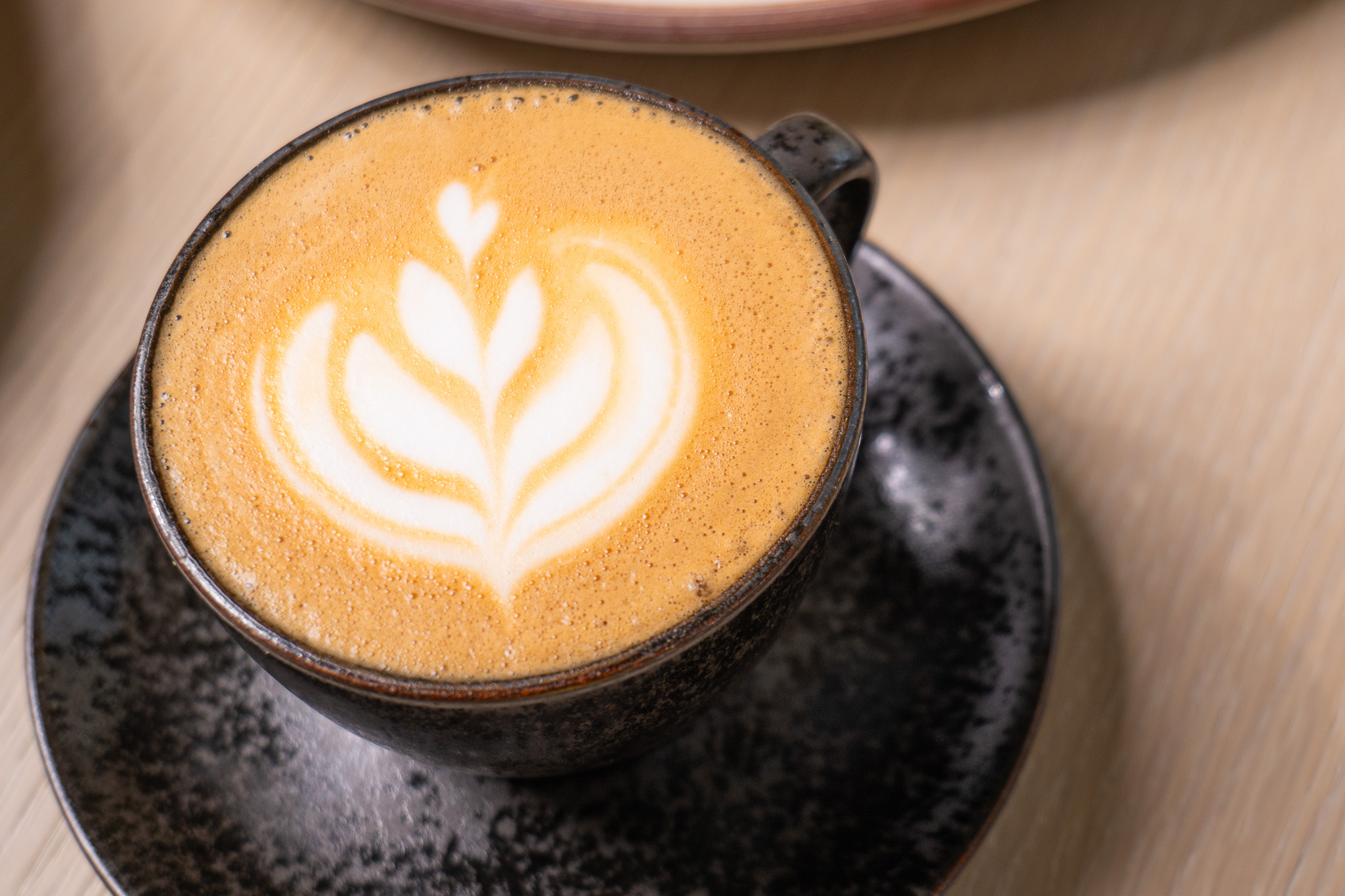 a cup of coffee with a design in the foam