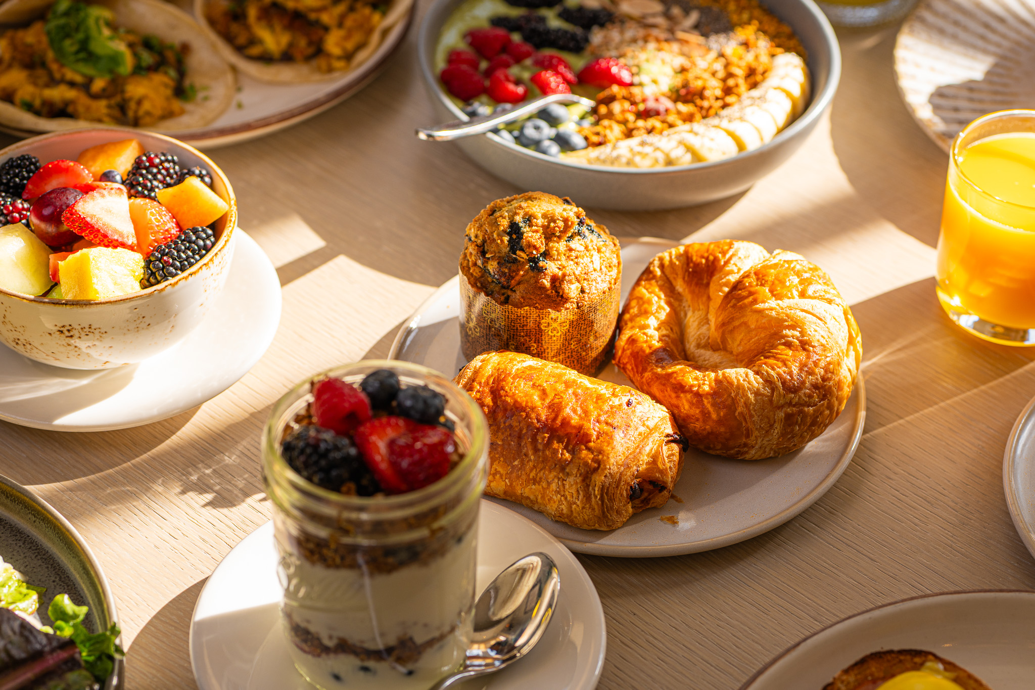 a table with plates of food and desserts