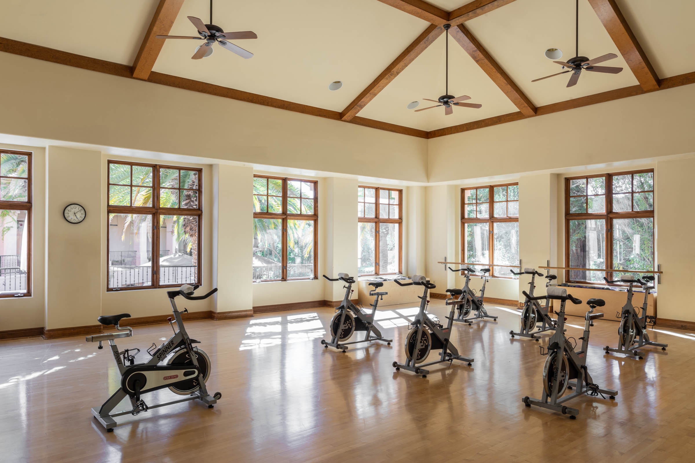 a room with exercise bikes and ceiling fans