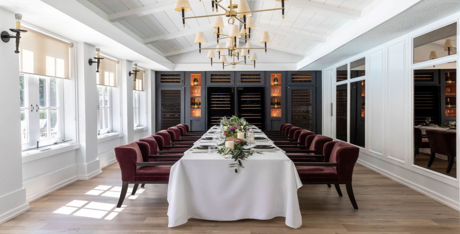 a long table with white tablecloth and red chairs