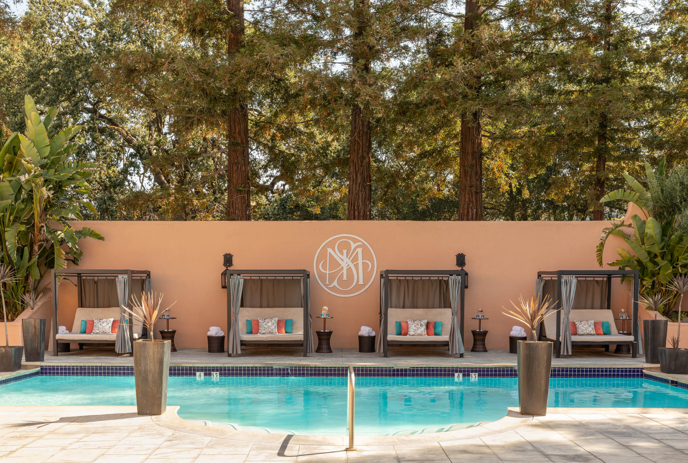 a pool with chairs and trees in the background