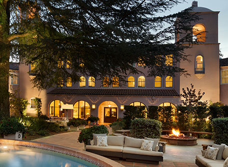 a large building with a pool and a fire pit