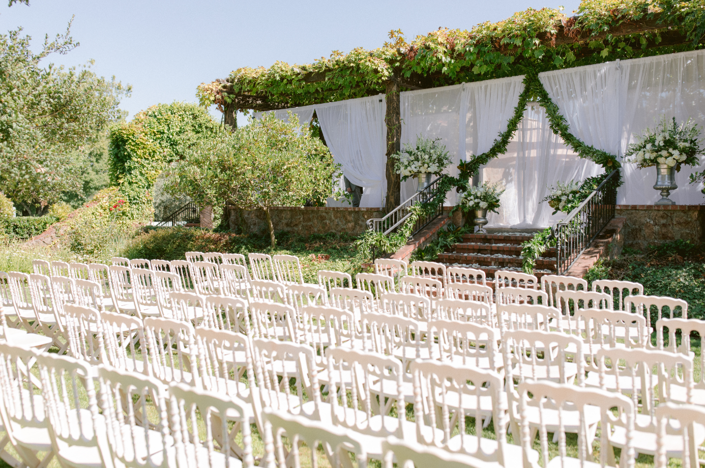 rows of white chairs in a garden