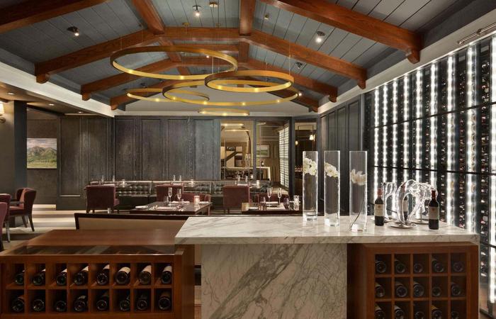 a bar with wine bottles and glasses