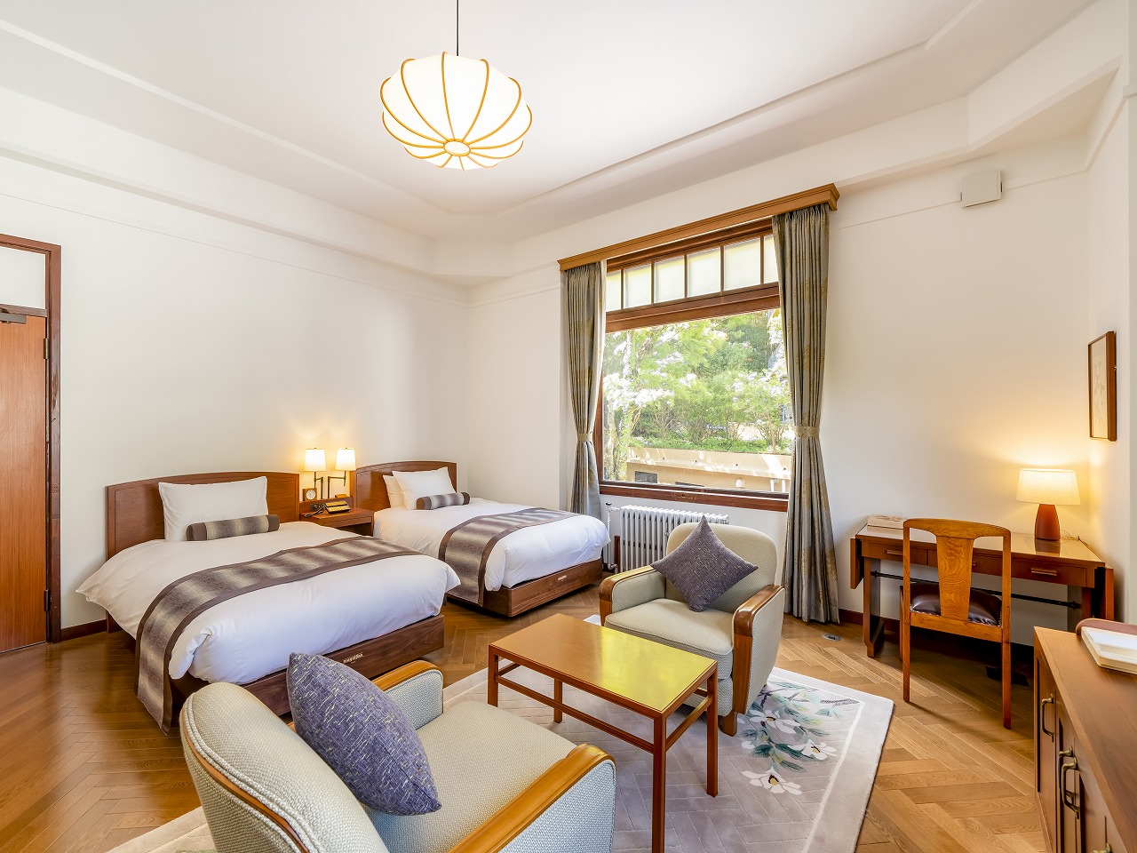 a room with two beds and a table and chairs