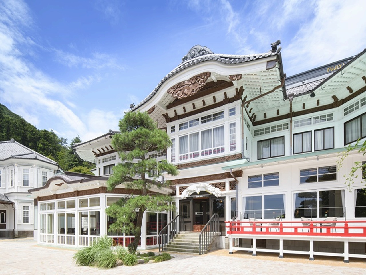 a building with a tree and a red railing
