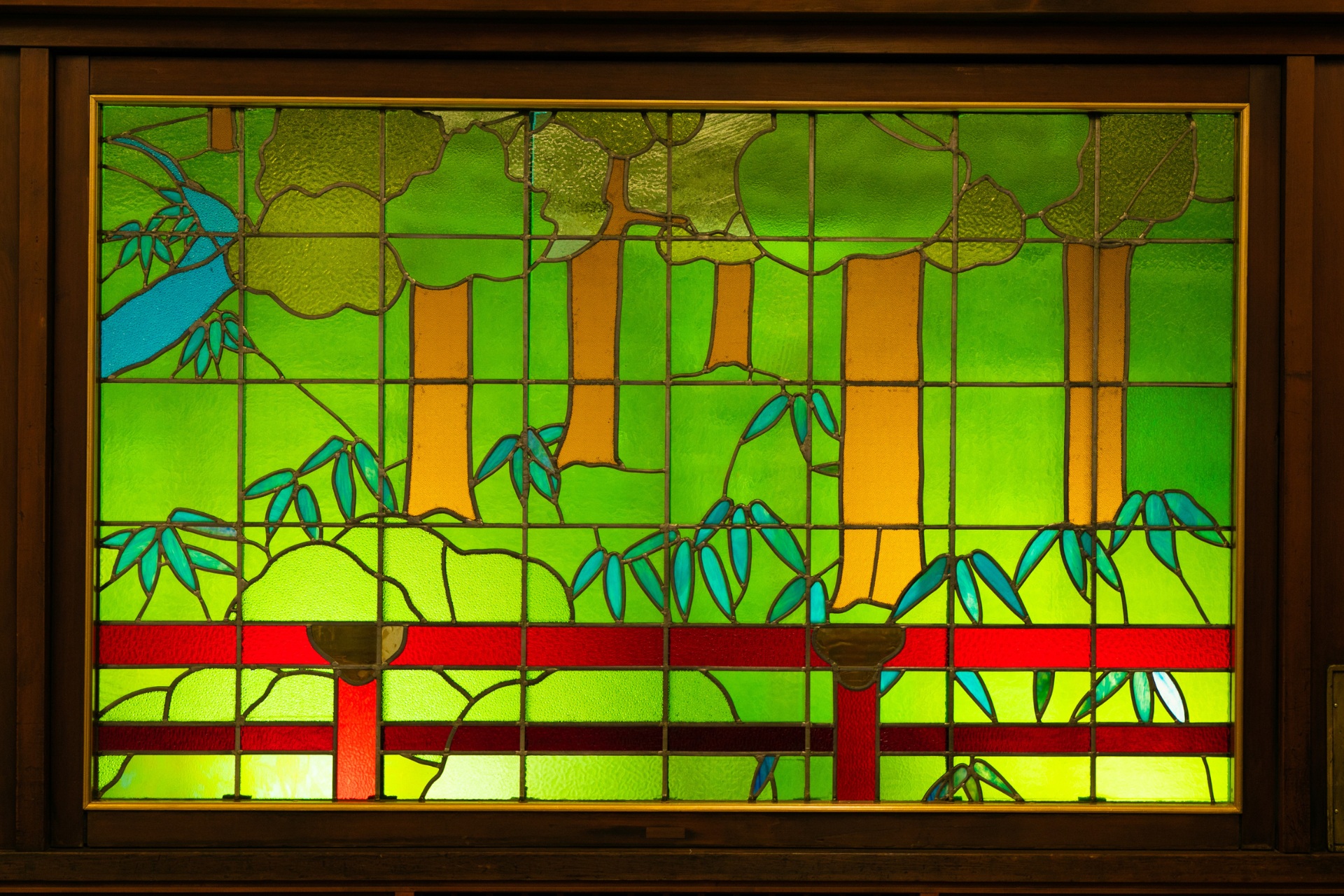 a stained glass window with trees and red railings
