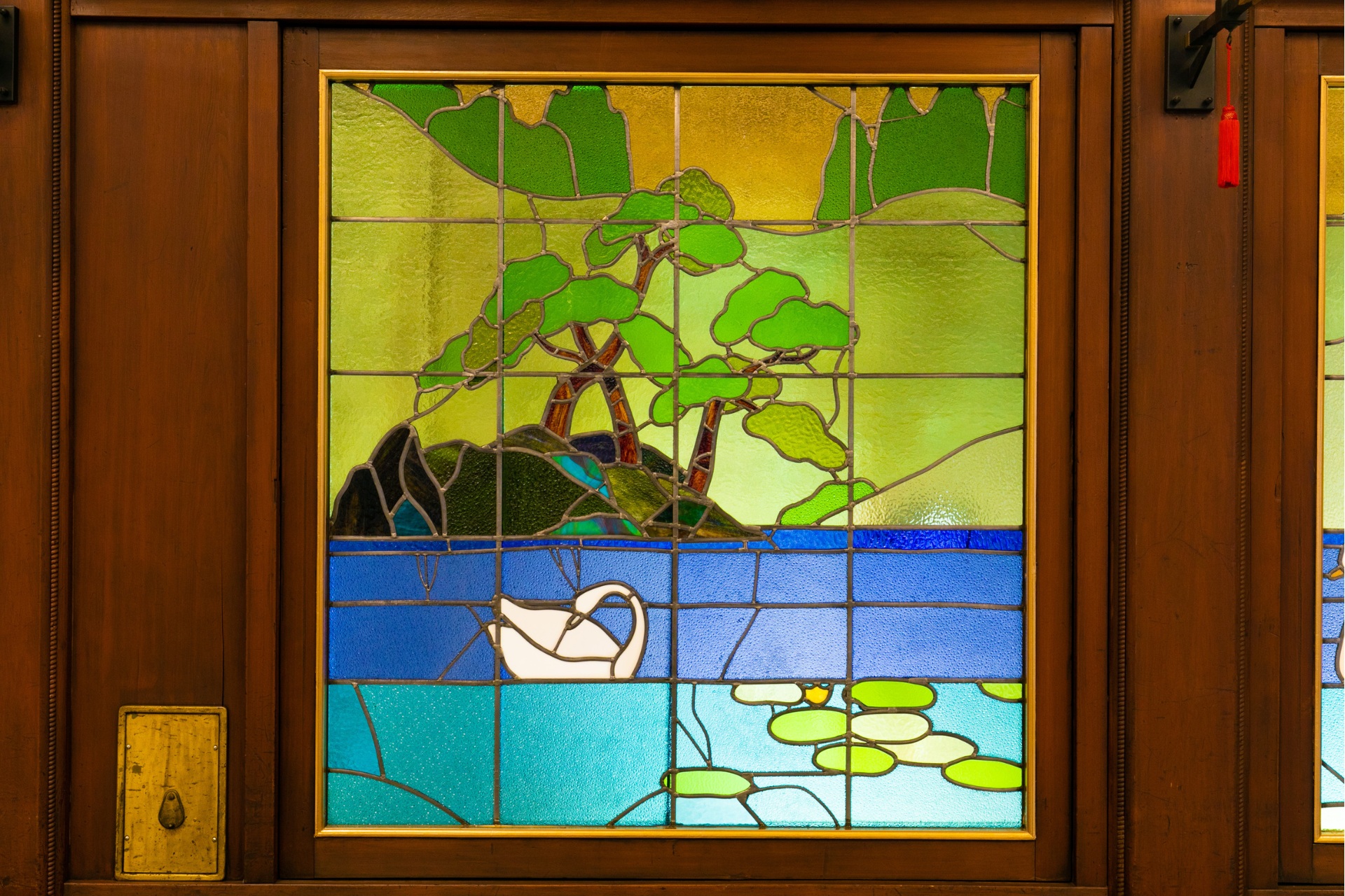 a stained glass window with a swan on the water