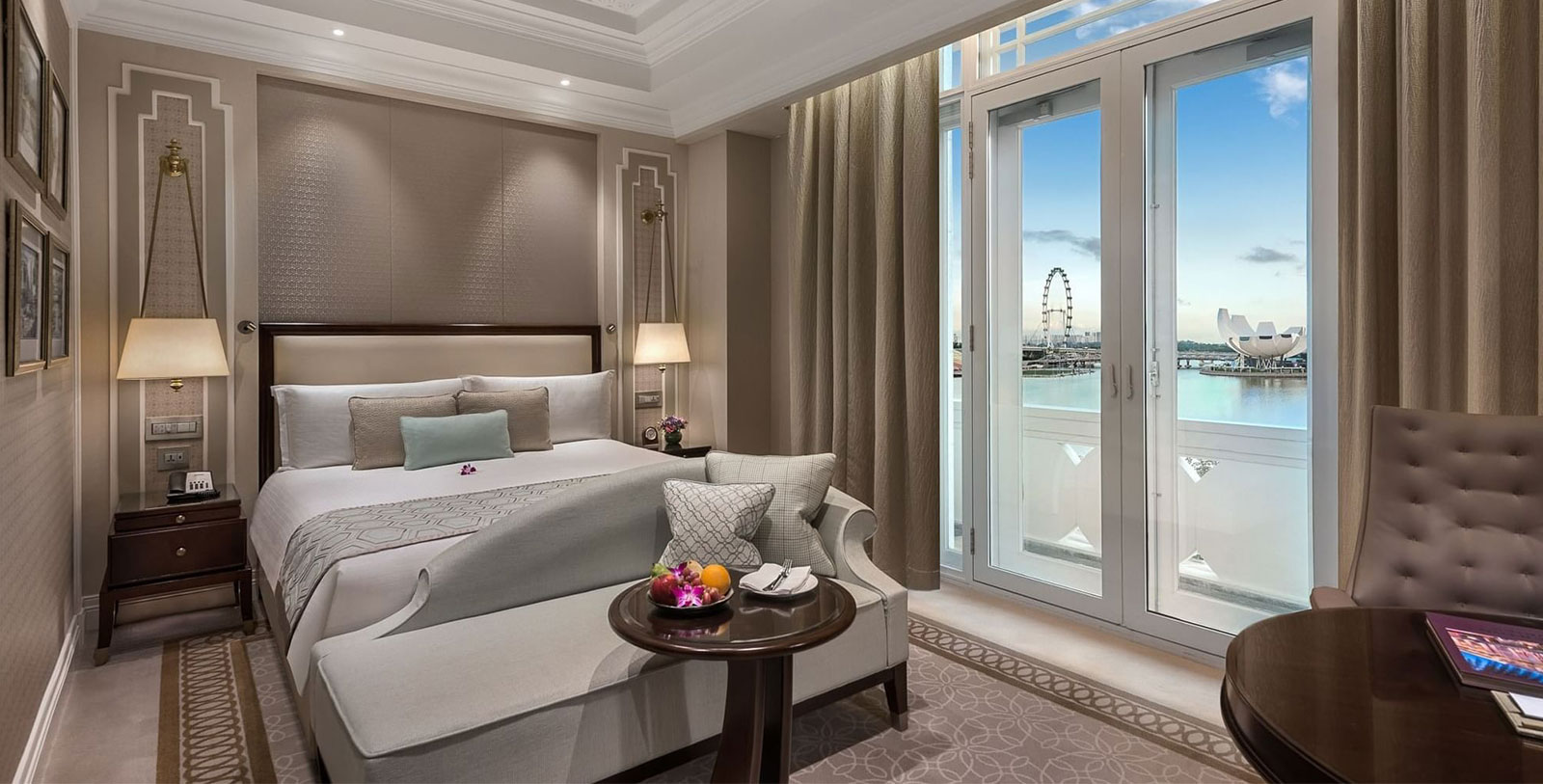 a room with a bed and a table with glass doors