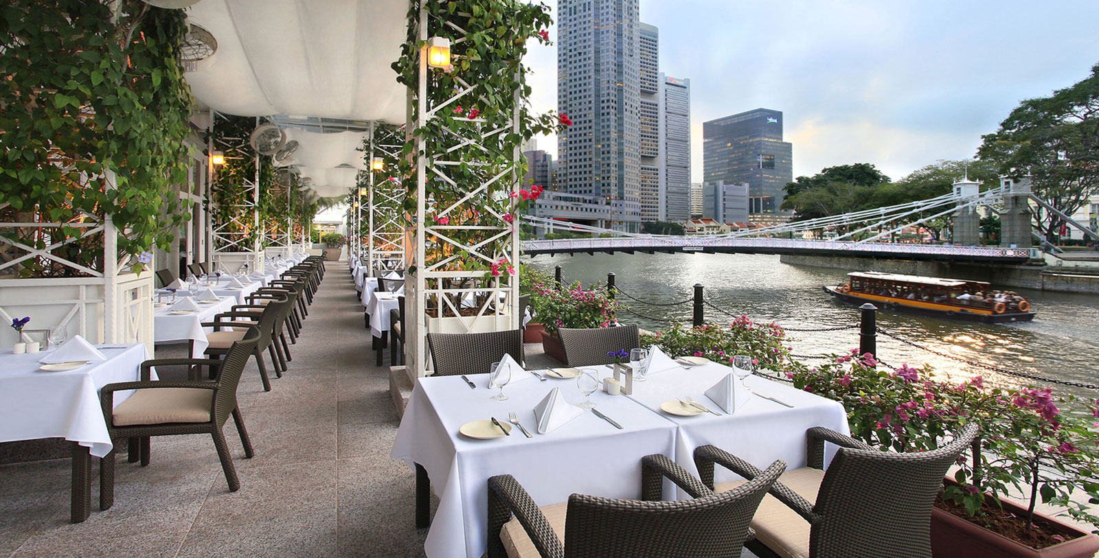 a restaurant with tables and chairs by water