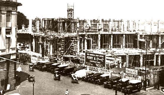 a building under construction with cars and people