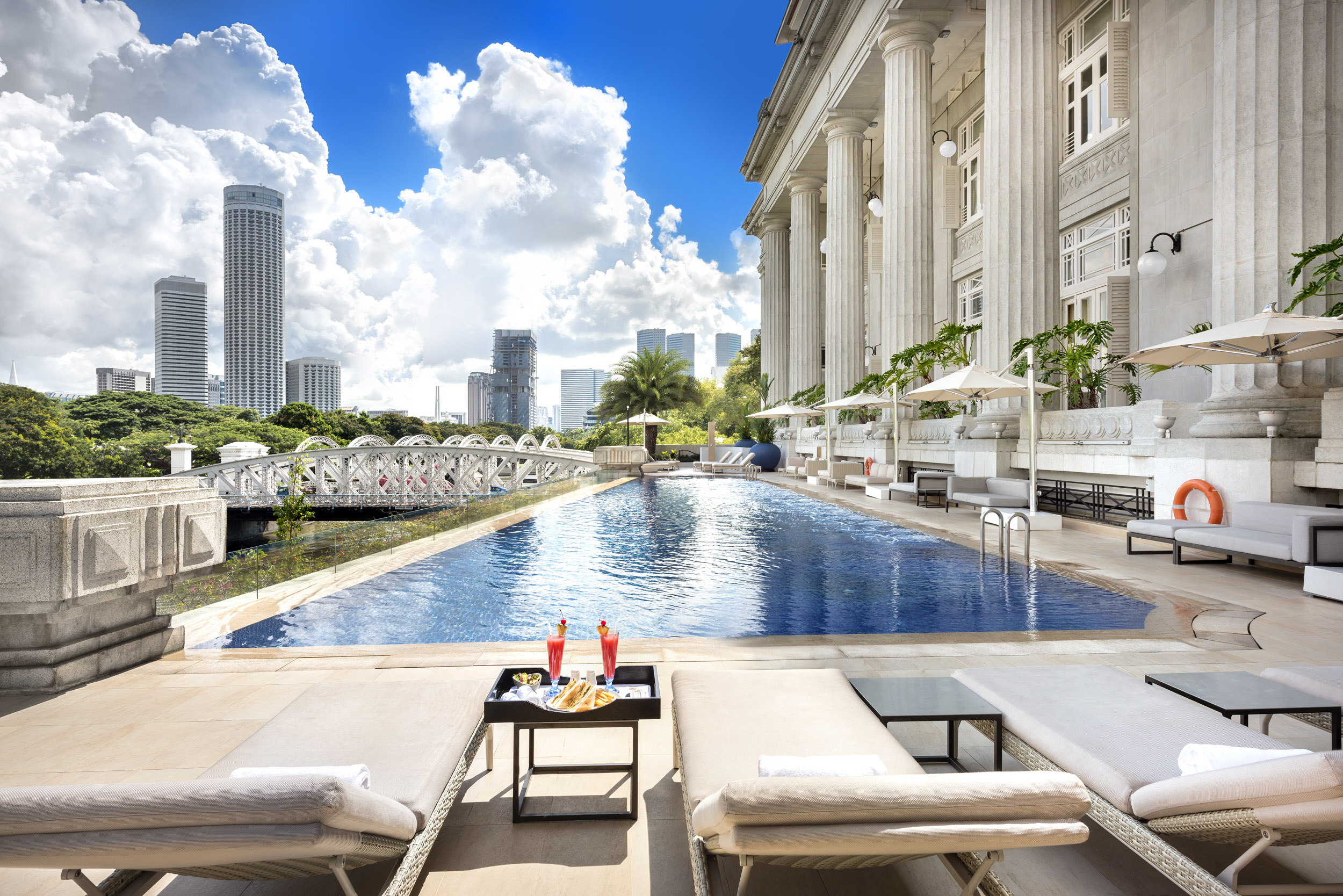 a pool with a large building and a bridge