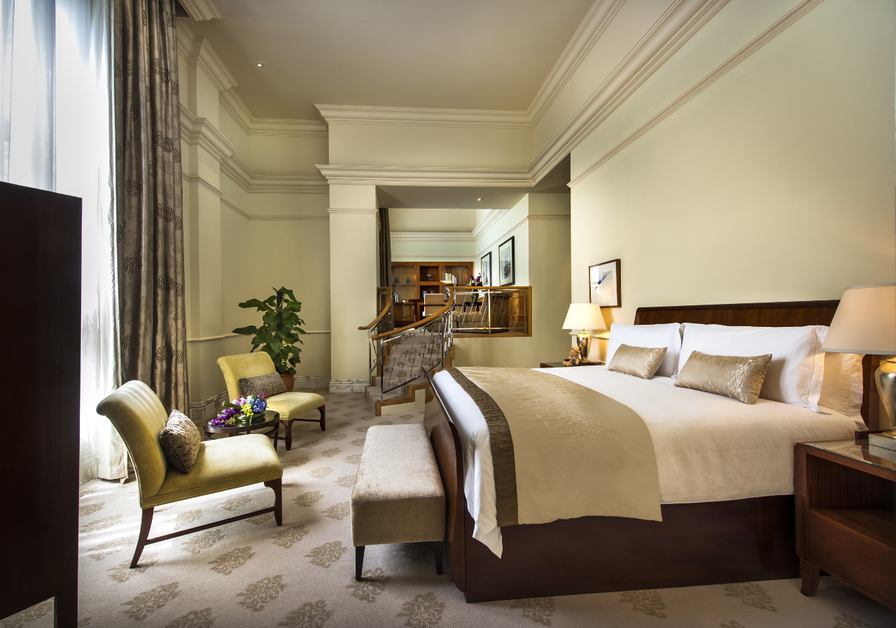 a bedroom with a bed and chairs