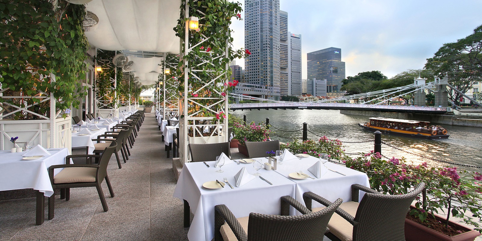 a restaurant with tables and chairs by a river