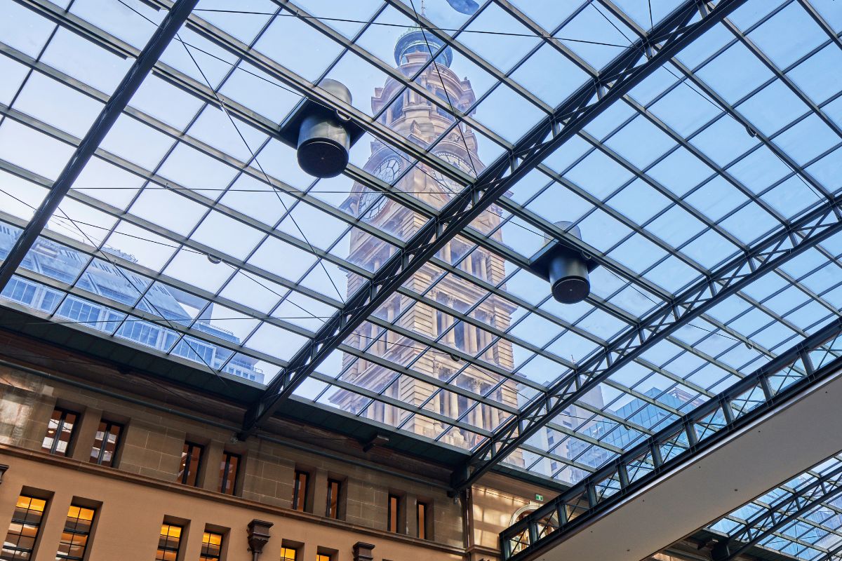 a glass roof with a tower in the background