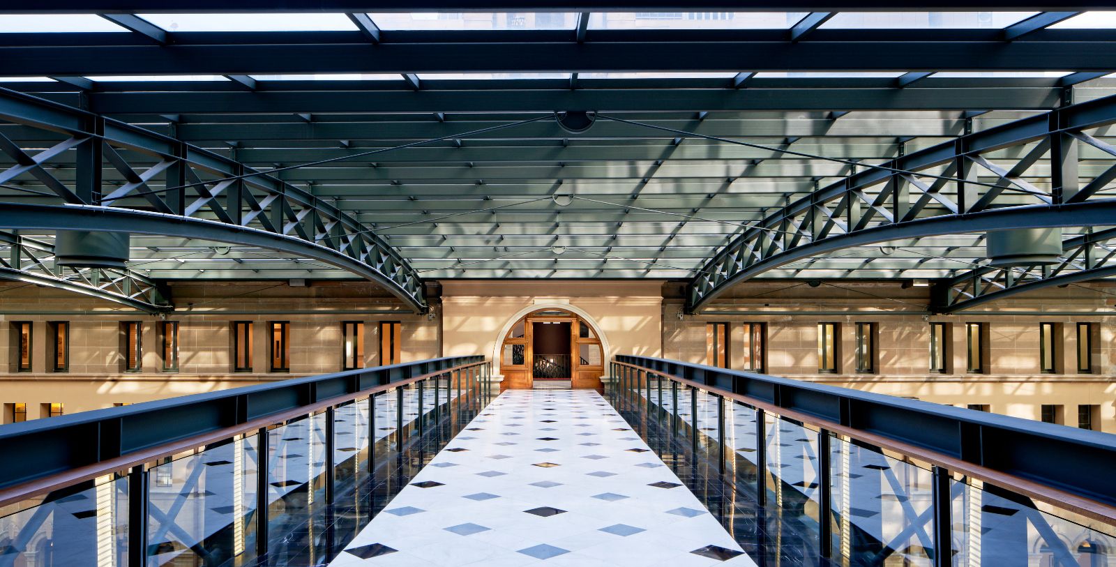 a walkway with railings and glass ceiling