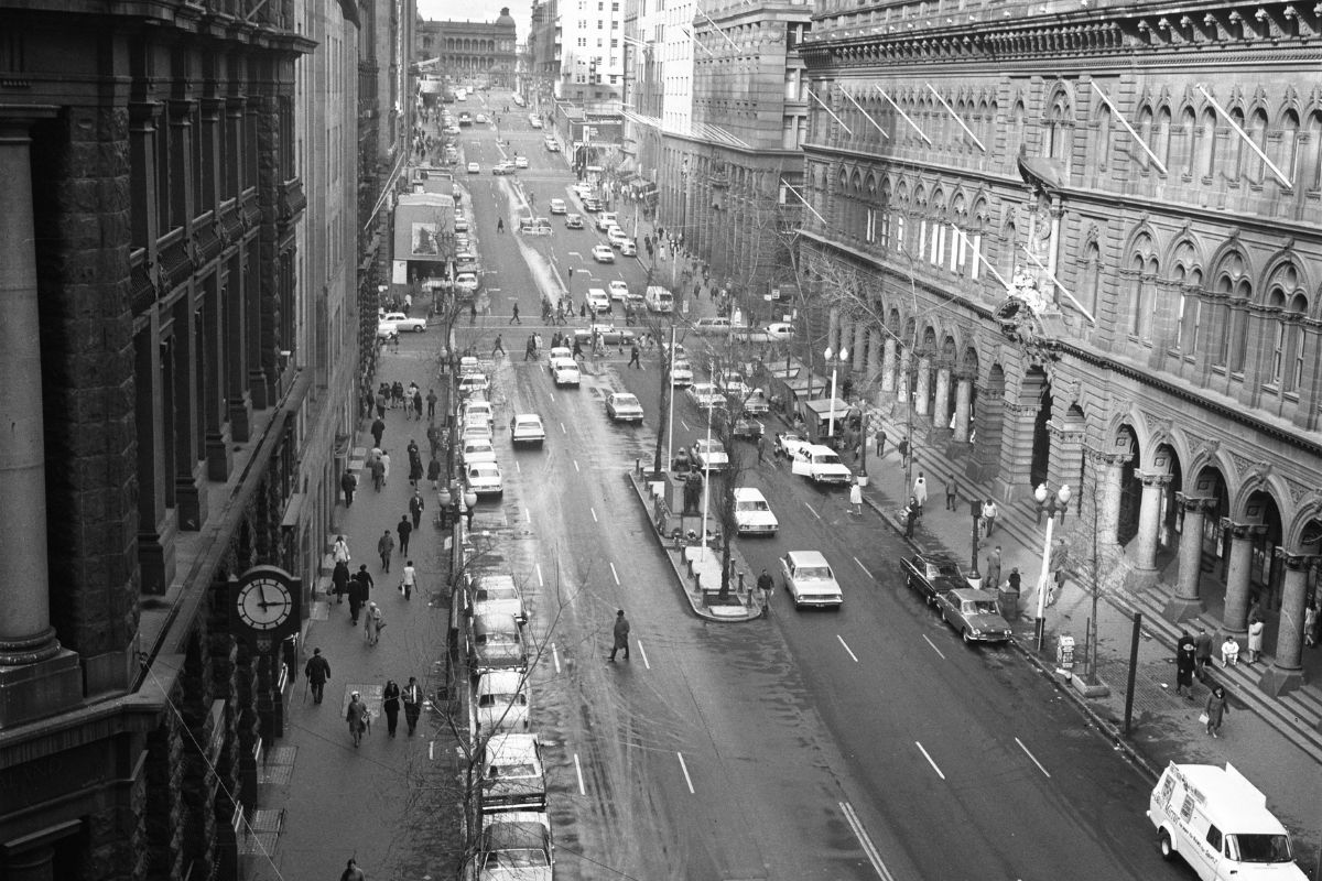 a street with cars and people walking on it