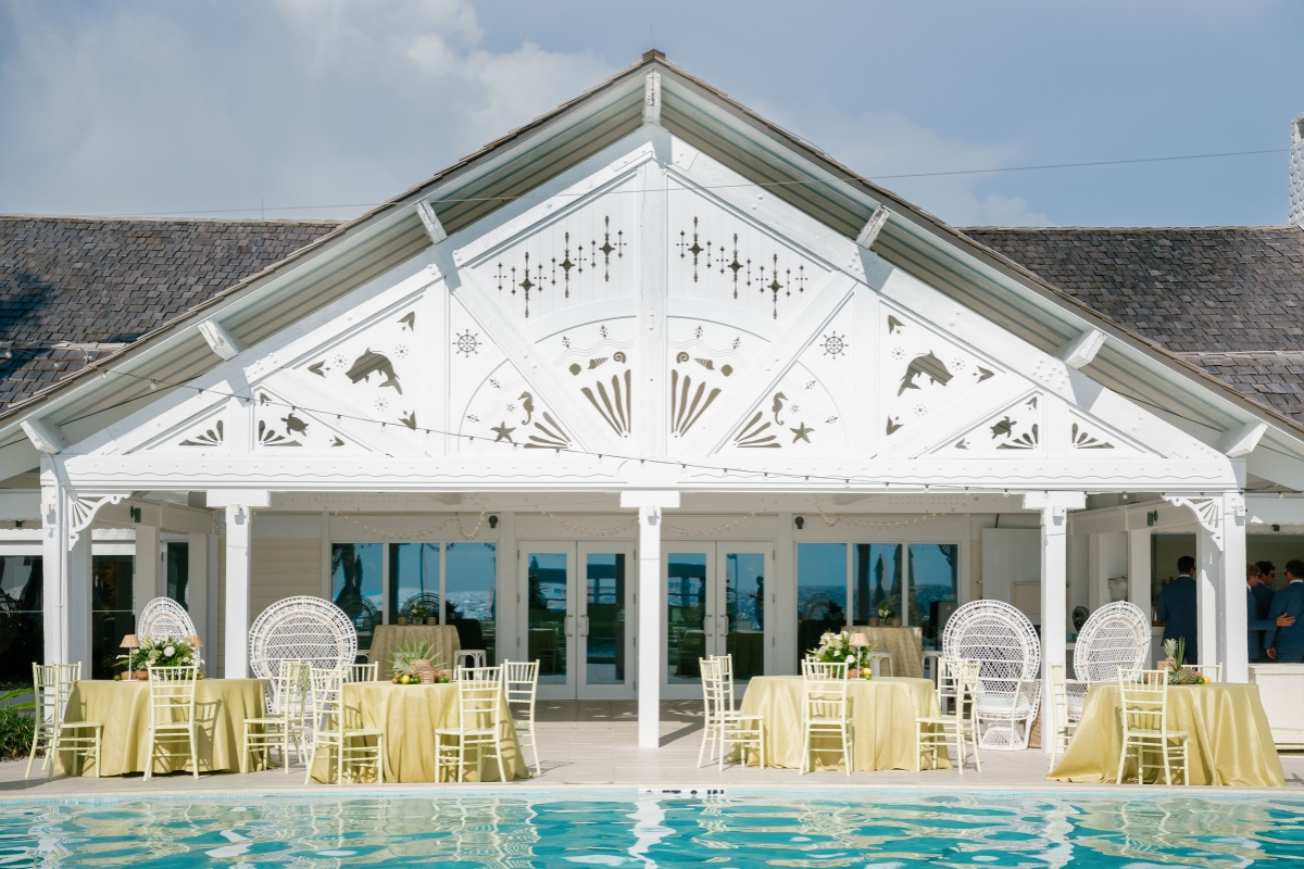 a pool with tables and chairs in front of a building