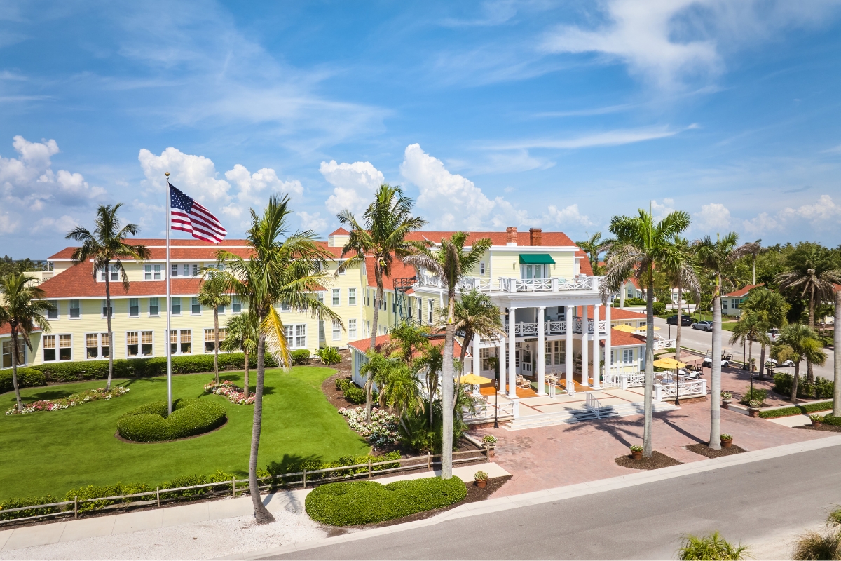 a building with palm trees and a flag