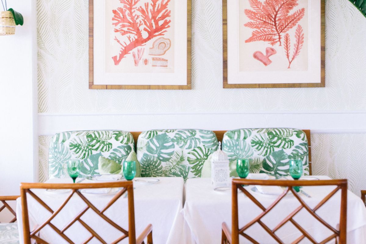 a table with green and white cushions and green glasses on it