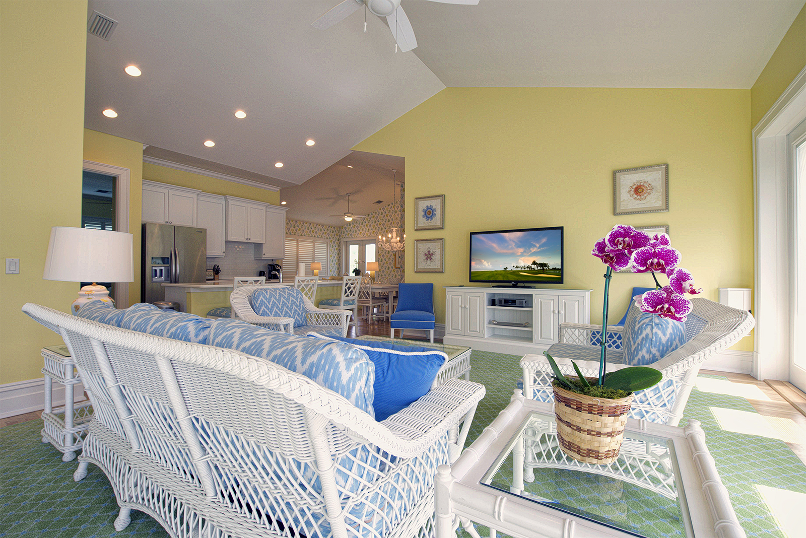 a living room with white wicker furniture and a television