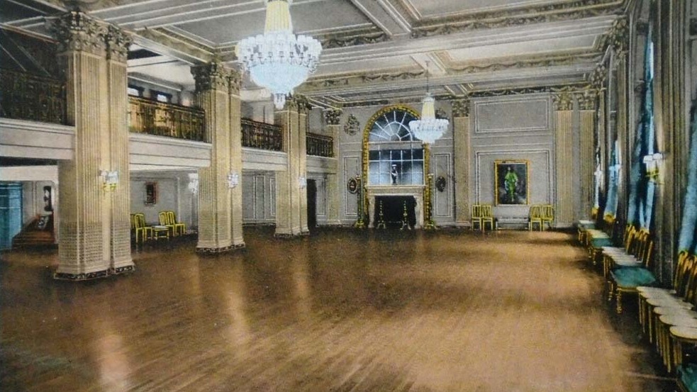 a large room with chandeliers and a fireplace