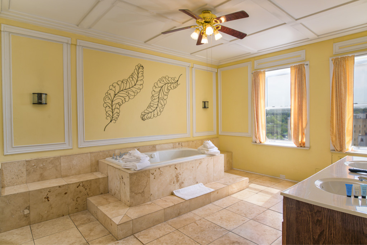a bathroom with a tub and a ceiling fan