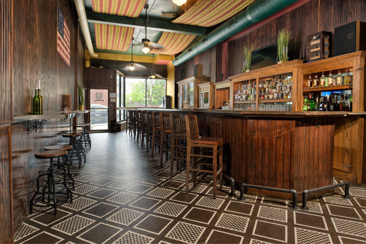 a bar with a wooden counter and chairs