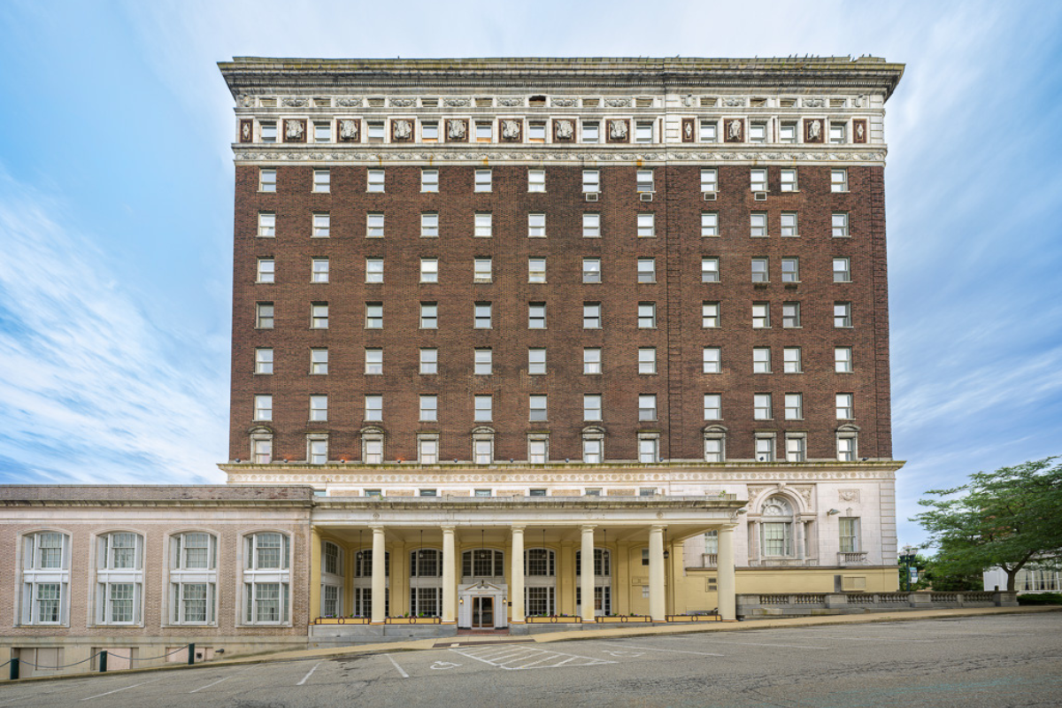 a large building with columns and a parking lot