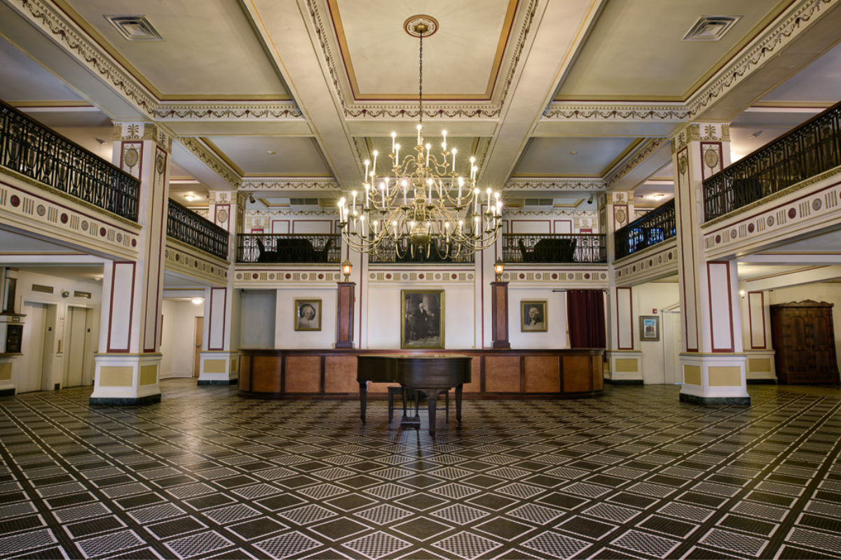 a room with a piano and chandelier